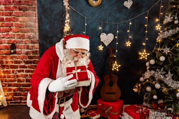 istock Santa Claus with Christmas present box 1290478549