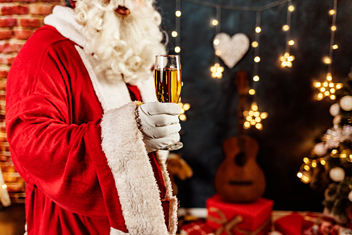 Santa Claus holding up a champagne flute.