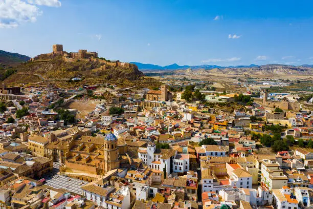 Aerial view of Spanish city of Lorca overlooking Collegiate church of St. Patrick and ancient castle on hilltop on sunny autumn day