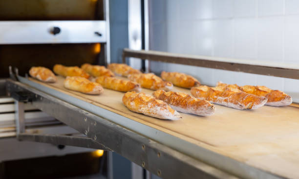 istock Freshly baked baguettes near oven in bakery workshop 1290480286