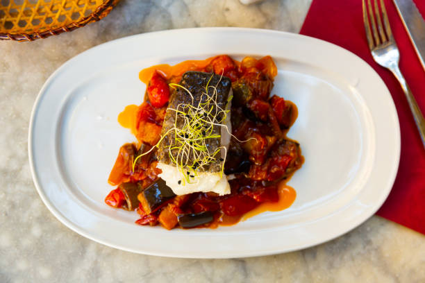 Pappa al pomodoro, a typical Tuscan food, with seafood on top. The plate is ready at the restaurant.