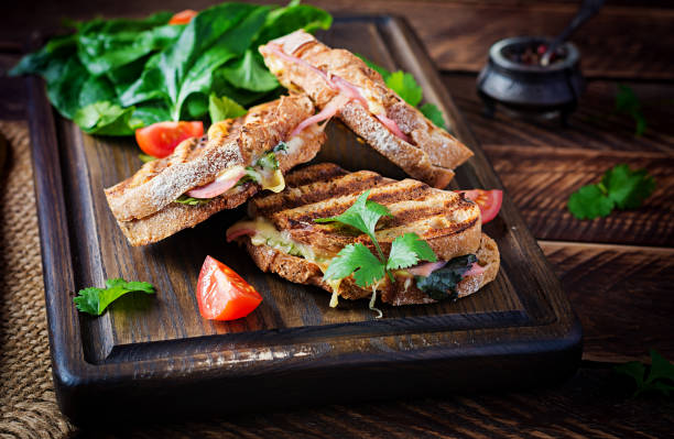 istock Grilled sandwich panini with ham, tomato, cheese and spinach. Delicious breakfast or snack. Copy space 1290486839