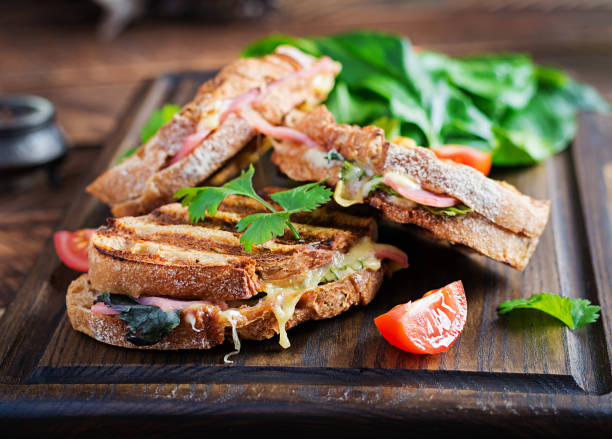 istock Grilled sandwich panini with ham, tomato, cheese and spinach. Delicious breakfast or snack. Copy space 1290486852