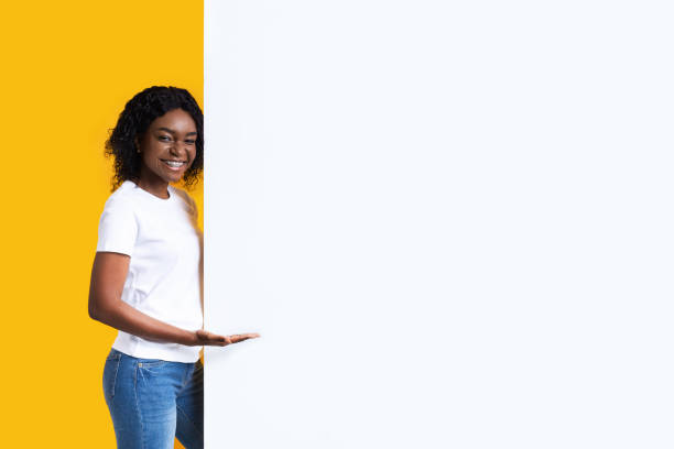 istock Attractive black woman showing blank advertisement board 1290487065