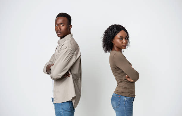 istock Upset black couple standing back to back on gray background 1290487375