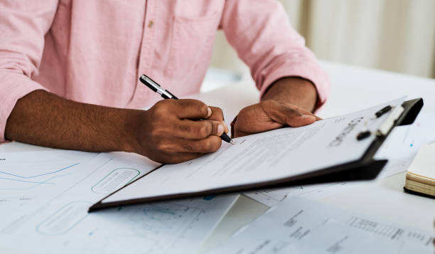 Jotting his signature on some important paperwork Closeup shot of an unrecognisable businessman filling in paperwork in an office personal loan stock pictures, royalty-free photos & images