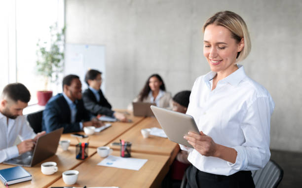 istock Happy Businesswoman Using Digital Tablet Computer Standing In Modern Office 1290488092