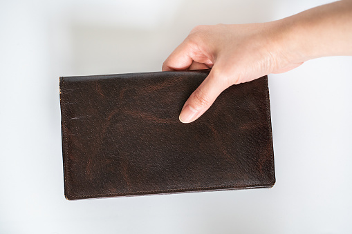 Brown leather wallet; payment gesture