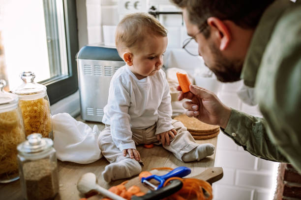istock Father preparing food in kitchen for baby boy 1290489853