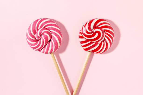 istock Two sweet lollipop candy on pink background. 1290490915