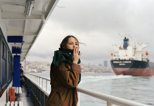 Young Caucasian woman smoking cigarette while  traveling on ferry in Istanbul