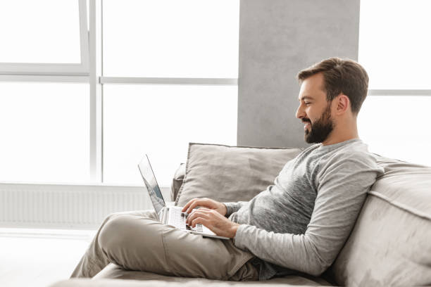 istock Portrait of a smiling young man working on laptop 1290491179