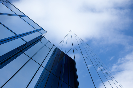 Abstract modern architecture details, urban facade made of steel framework and shiny glass is under blue sky
