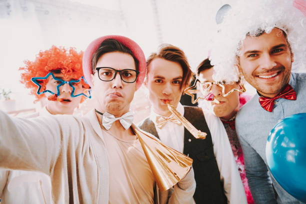 Gay guys taking selfie on phone at party. Gay guys in bow ties taking selfie on phone at party. gay man men sunglasses party stock pictures, royalty-free photos & images