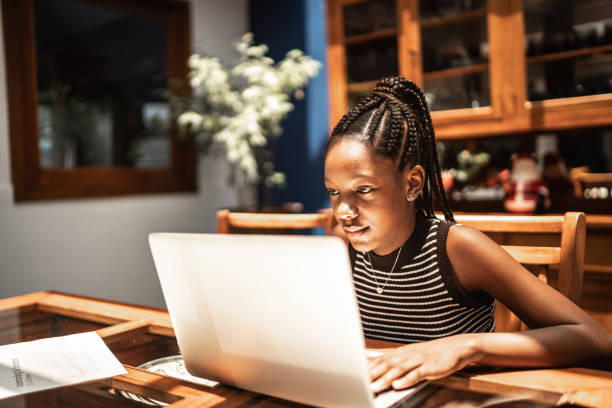 Teenager girl using laptop at home (homeschooling or watching some video) Teenager girl using laptop at home (homeschooling or watching some video) junior high photos stock pictures, royalty-free photos & images