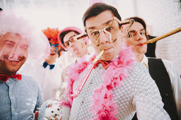 Gay guys taking selfie on phone at party. Gay guys in bow ties taking selfie on phone at party. gay man men sunglasses party stock pictures, royalty-free photos & images