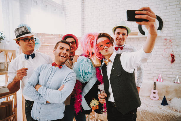 Gay men taking selfie on phone at party. Gay men in bow ties taking selfie on phone at party. gay man men sunglasses party stock pictures, royalty-free photos & images