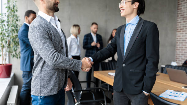 istock Two Businessmen Shaking Hands After Successful Negotiations In Office 1290494331