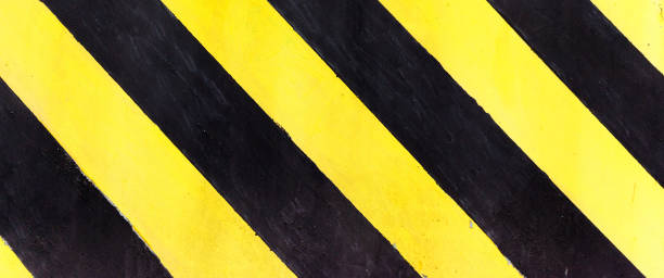 istock Safety stripes on construction site, Black and yellow Under construction sign over a grunge texture, top view 1290495008