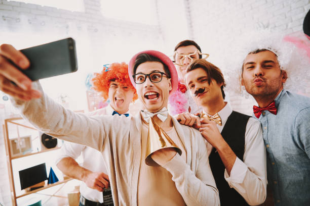 Gay guys taking selfie on phone at party. Gay guys in bow ties taking selfie on phone at party. gay man men sunglasses party stock pictures, royalty-free photos & images