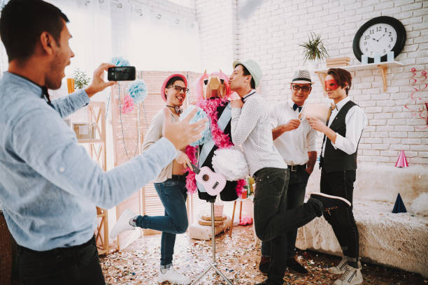 Gay men taking selfie on phone at party. Gay men in bow ties taking selfie on phone at party. gay man men sunglasses party stock pictures, royalty-free photos & images