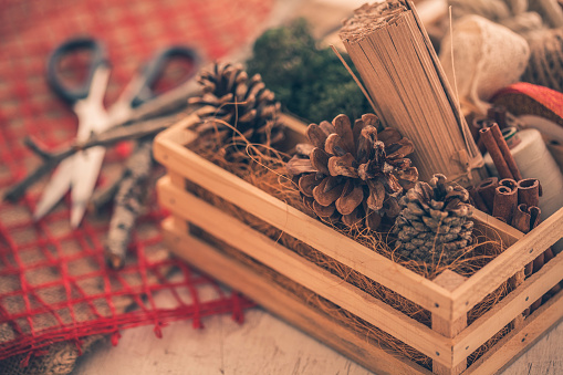High angle view of a wooden crate with rustic looking decorations for making arts and crafts for Christmas.