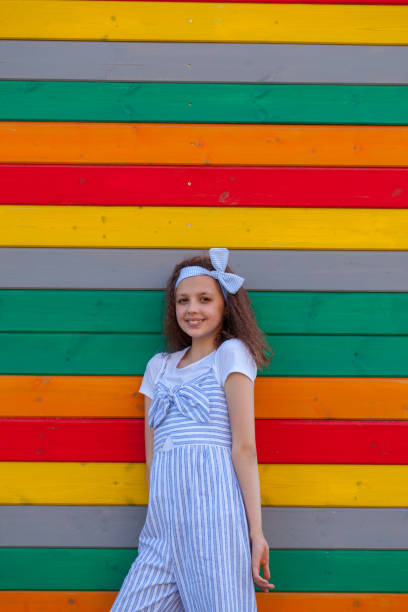 une fille de 8-10 ans se tient près du mur - 10 11 years cheerful happiness fun photos et images de collection