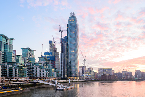 Wide angle view of skyscraper, construction cranes, and developing residential community on southern bank of the river.