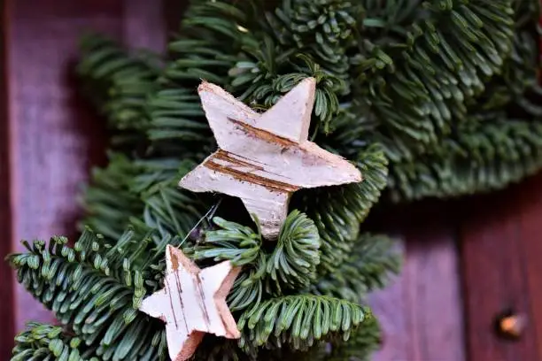 close up of a fir branch with two wooden stars