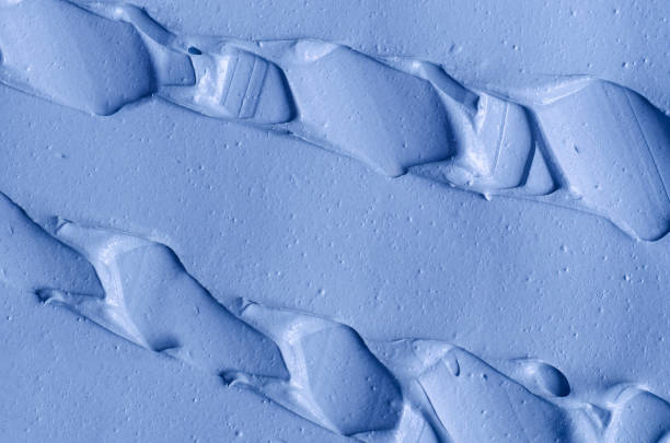 istock Light blue facial clay (mask, face cream, body wrap) texture close up, selective focus. Abstract background with brush strokes. 1290499041
