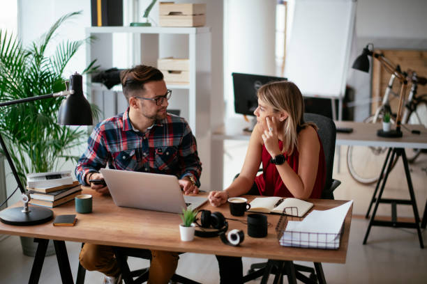 istock Businesspeople with laptop discussing new projects in office. 1290504659