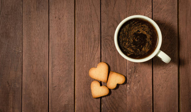 istock Hear shaped cookies and a cup of coffee on wooden table. Copy space. 1290507391