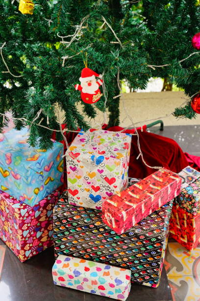 istock Santa on tree and Gift Box of Christmas presents under a Christmas tree 1290507608