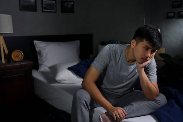 istock A depressed young man suffering from insomnia sitting in bed 1290508235