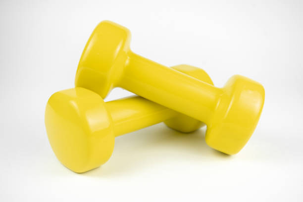 istock Two yellow dumbbells on white background 1290508272