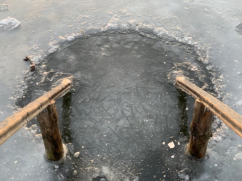 An ice hole with wooden rails prepared for swimming on the feast of the baptism of Jesus Christ.