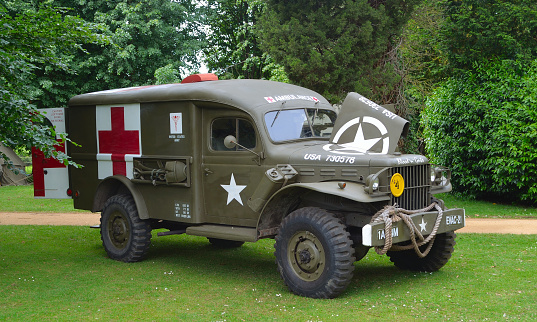 Silsoe, Bedfordshire, England - May 28, 2017:  Second World War  Ambulance parked in front of trees.