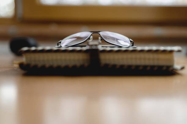 istock Frontal view leather vintage notebook with glasses. 1290521571