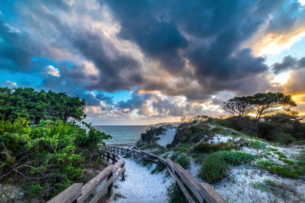 istock Dark clouds and shining sun over Alghero shore at sunset 1290526162