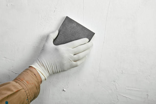 Sanding and repairing a wall stock photo