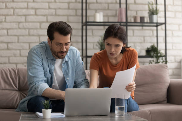 istock Focused young married couple looking at computer screen, planning budget. 1290529076
