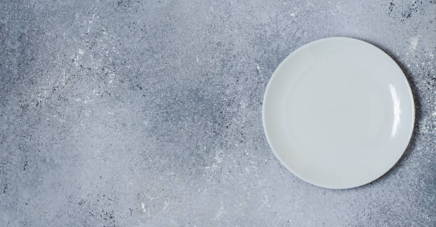 istock Blue concrete textured background for design with ceramic plate for food. Copy space 1290529399