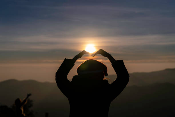 istock silhouette girl doing heart shape 1290531687