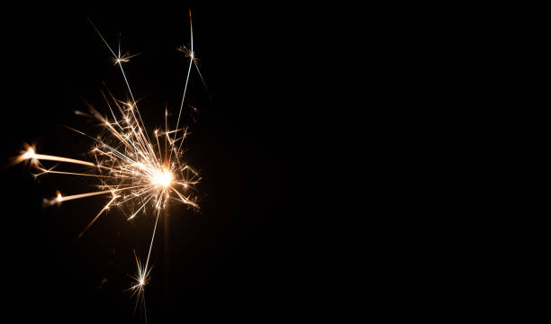 istock Burning sparkler on a black background with place for text. New year, birthday 1290535505