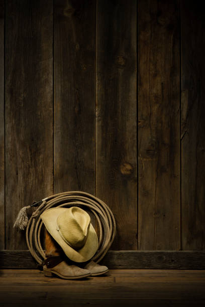 istock Cowboy hat,boots and lasso with barnwood background 1290535606