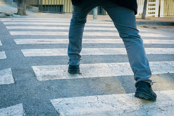 obsessive compulsive disorder, man trying not to step on the black lines of a pedestrian crossing - obsessive imagens e fotografias de stock