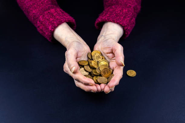 coins in the hands of a pensioner ten-ruble coins are poured into the hands of a pensioner, the concept of poverty gold and silver ira stock pictures, royalty-free photos & images
