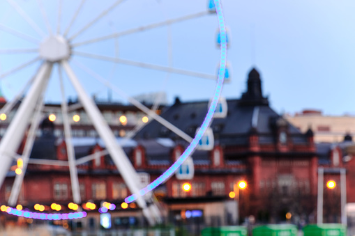 Blurred view of Ferris wheel and historical neighborhood of Helsinki in the evening.