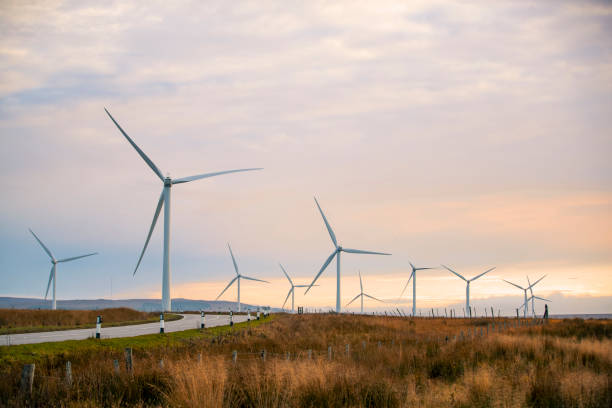 Wind Energy In Scotland A beautiful sunset in the Scottish highlands with renewable energy wind turbines far into the horizon windmill sunset stock pictures, royalty-free photos & images