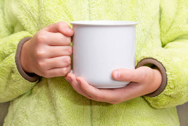 istock Girl is holding white cup in hands. 1290546705